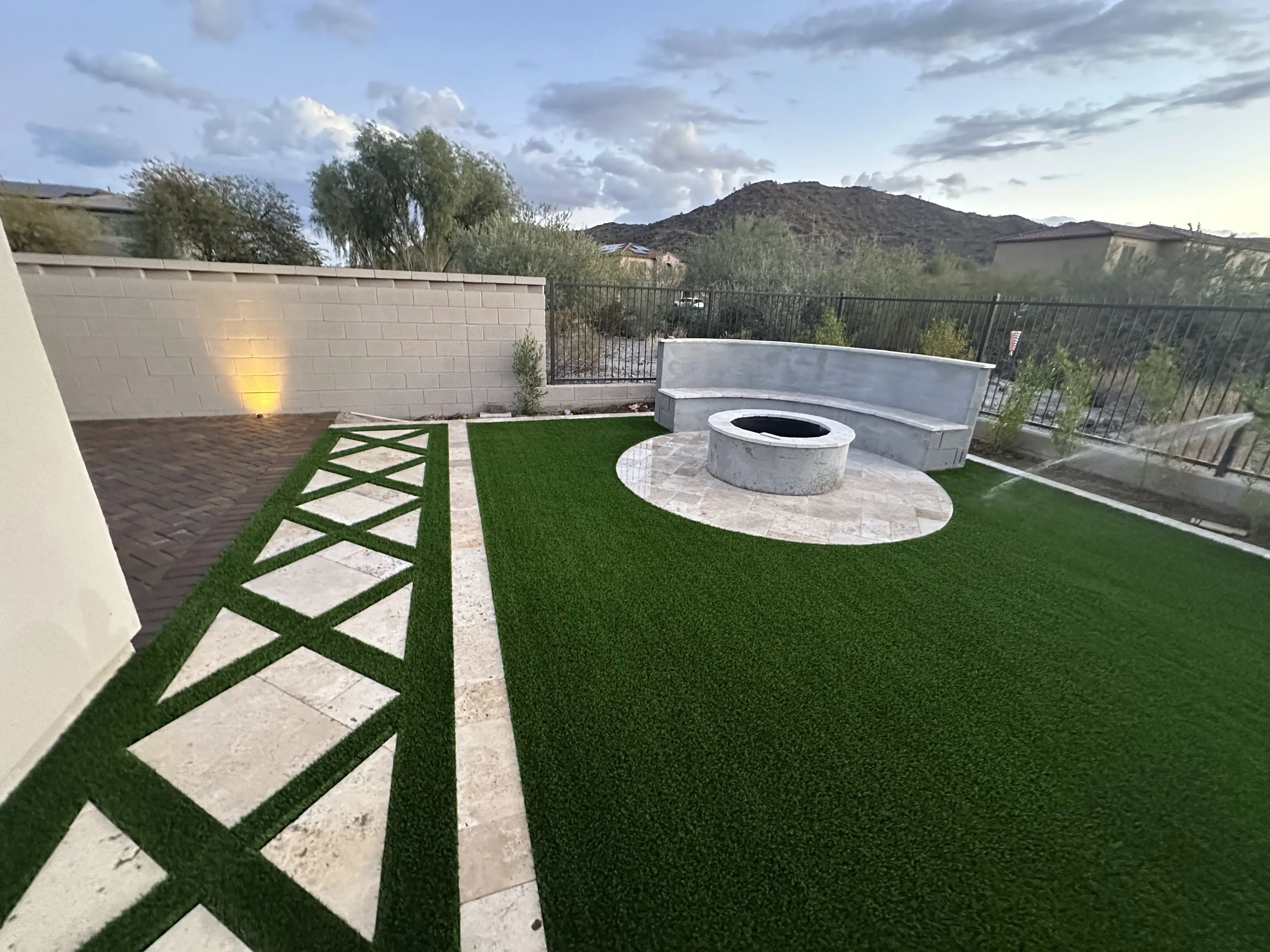 After: Backyard transformation with artificial grass and extended paver patio