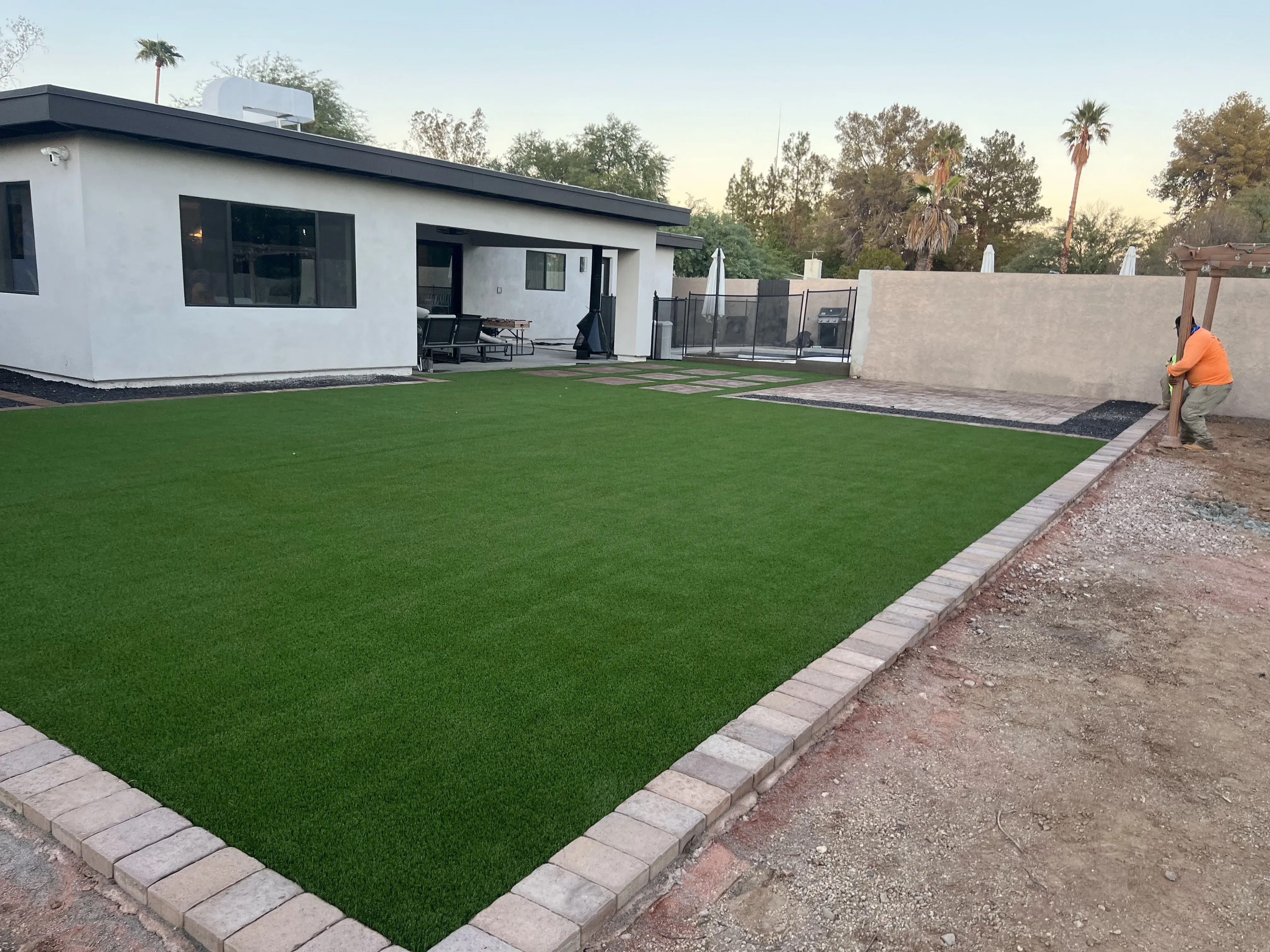 After: Backyard transformation with artificial grass and extended paver patio